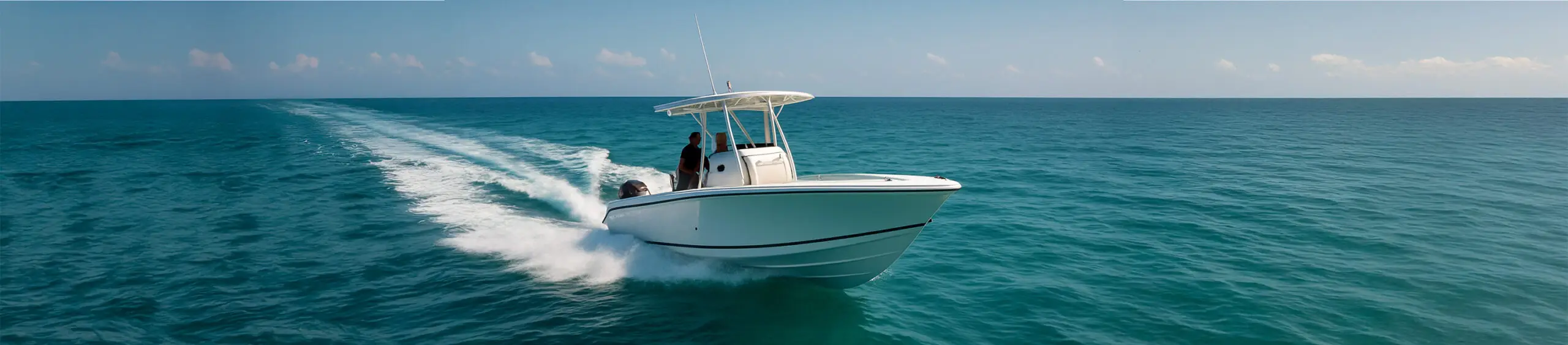 Sleek white center console boat cruising through turquoise water under a clear blue sky