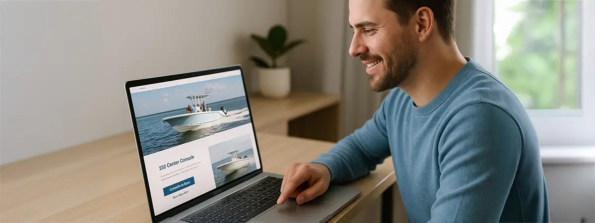 Man smiling while clicking a contact button on a boat brand’s website